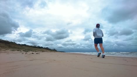 Man-is-running-in-the-beach-in-the-morning