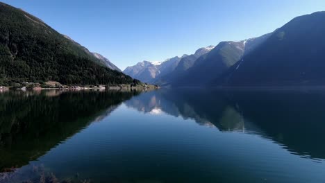 A-calm-reflective-fjord-in-Norway-with-trees-and-mountains
