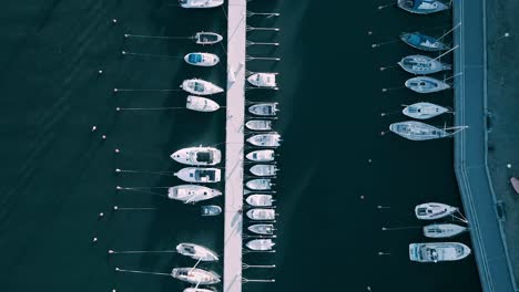 Aerial-tracking-shot-looking-directly-down-at-jetty-with-boats-moored