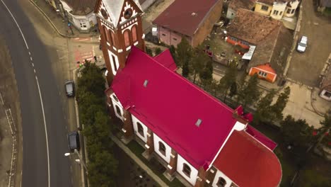 Aerial-Drone-Close-Up-and-Fly-over-Of-red-roofed-church-in-a-small-Community-city-village-in-romania-Countyside-provance