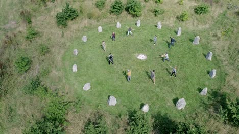 A-group-of-people-practice-zen-like-stick-martial-arts-in-an-ancient-stone-circle