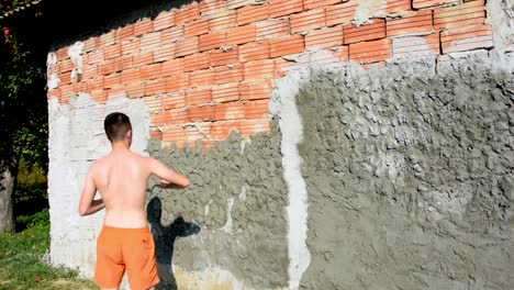 Young-man-working-hard-to-build-facade-of-a-house-this-summer