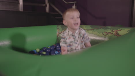 A-Young-Boy-Plays-in-Ball-Pit-and-Throws-Balls-Around-whilst-Smiling---Ungraded