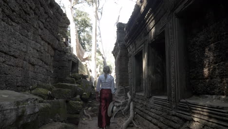 Beautiful-woman-walking-through-ancient-ruins-of-old-stone-temple-in-Cambodia