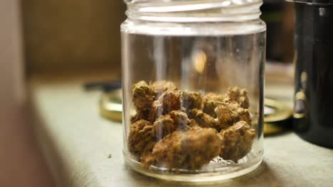 Jar-of-cannabis-buds-is-set-on-counter-top