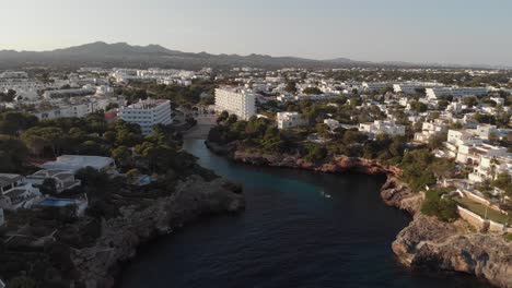 AERIAL:-Lovely-mediterranean-city-with-beautiful-bay-on-Mallorca,-Spain