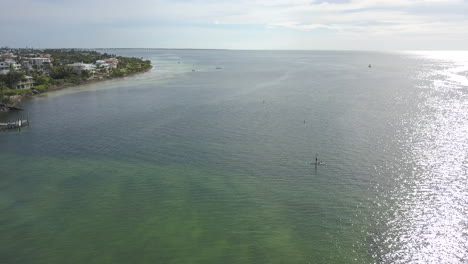 Rotation-drone-shot-of-paddle-boarder-in-ocean-into-the-sunset