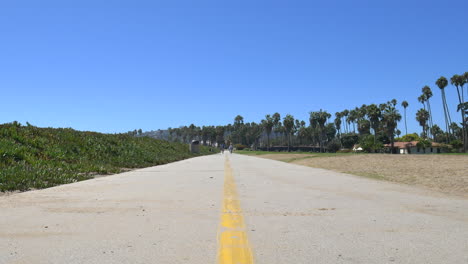 An-Einem-Sonnigen,-Klaren-Tag-In-Santa-Barbara,-Kalifornien,-Stehen-Zwei-Biker-Auf-Dem-Strandradweg-Und-Fahren-Gemeinsam-In-Der-Ferne-Entlang-Der-Küste