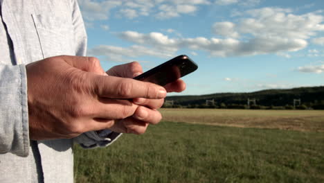 View-of-a-hand-holding-a-cell-phone-in-the-middle-of-nature