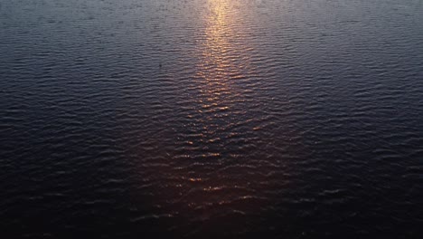 Sunbeams-reflecting-on-the-lake-surface-and-revealing-a-beautiful-sunset