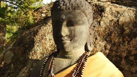 Close-up-of-a-stone-Buddha's-face-at-the-stupa-in-Red-Feather-Lakes,-CO