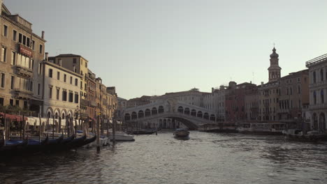 Wide-shot-of-Ponte-di-Rialto-bridge,-gondolas-and-surrounding-buildings-in-morning-light,-Venice,-Italy