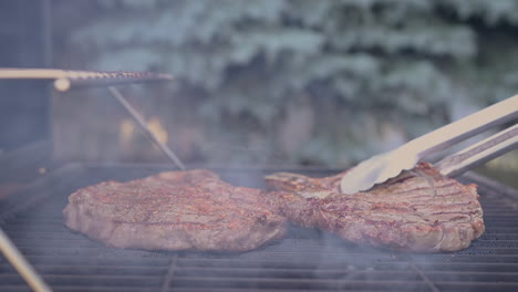 Seitenansicht-Von-Saftigen-Steaks,-Die-Brutzeln-Und-In-Heißen-Flammen-Umgedreht-Werden