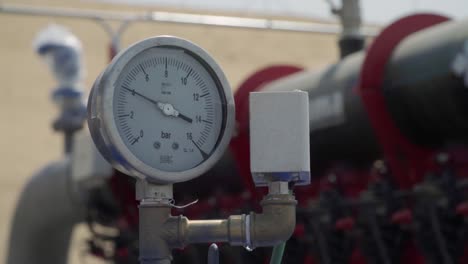 Manometer-pressure-meter-gauging-water-supply-at-industrial-farm,-Close-Up