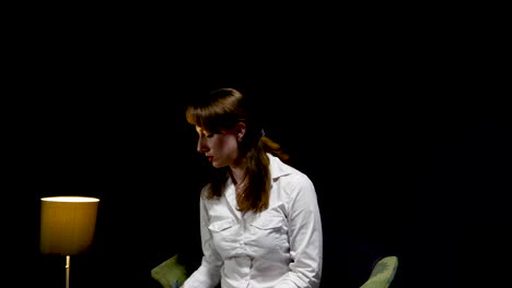 young-professional-woman-sits-alone-in-a-dark-waiting-room-and-gets-a-phone-call