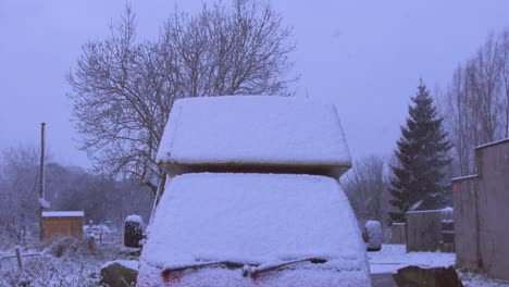 Slow-motion-snow-falling-on-snow-covered-van-in-the-countryside
