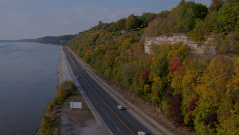 Aerial-pan-from-river-towards-beautiful-bluffs-over-the-Great-River-Road-in-Fall