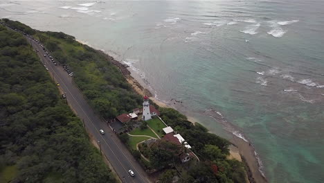 Aerial-view-of-a-roadside-lighthouse,-at-sundown,-on-the-island-of-Oahu,-Hawaii