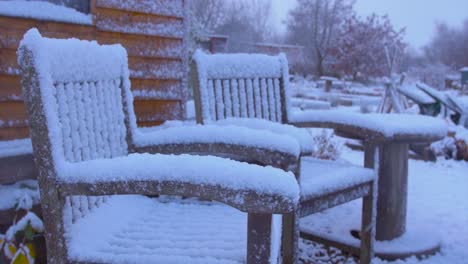 Two-chairs-covered-in-snow-as-it-continues-to-fall