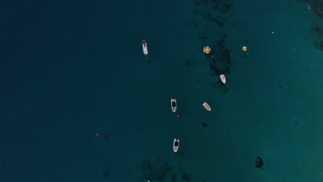 Aerial-spinning-shot-looking-down-on-leisure-boats-anchored-in-Konnos-Bay