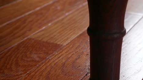 Close-up-shot-of-a-bedpost-scratching-a-hardwood-floor-as-the-bed-is-being-shaken-suggestively-from-activity-above