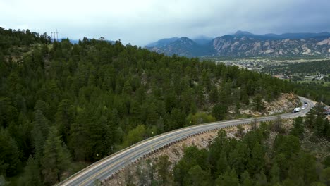Fly-Over-Asphalt-Road-And-Forested-Mountains-Near-Estes-Park-In-Northern-Colorado,-United-States