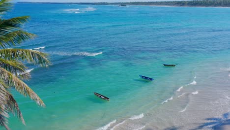 Traditional-fishing-boats-anchored-in-shallow-vibrant-turquoise-waters