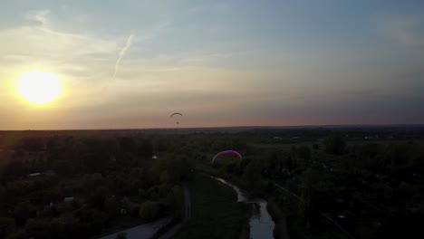 Two-Paragliders-over-the-river,-drone-aerial-in-Australia