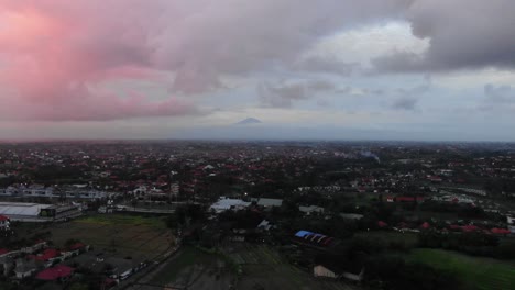 Aerial-View-of-Mount-Batur-Above-Canggu-with-Beautiful-Pink-Sunset-to-Left