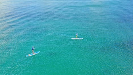Couple-on-sup-board-paddling-over-turquoise-waters-of-Dominican-Republic