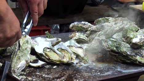 Man-open-oyster-on-the-grill