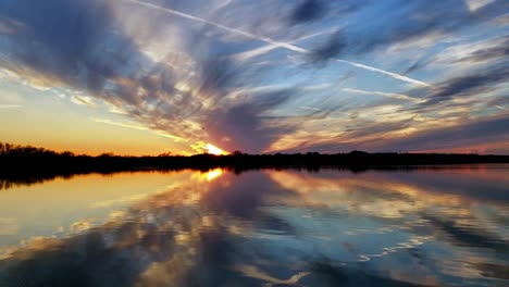 Kondensstreifen-In-Texas-Zeitraffer-Sonnenuntergang-über-See-Mit-Wolken-Und-Blauem-Himmel