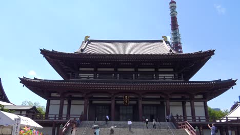 Zojo-ji-Temple,-Tokyo-Tower-and-people-walking-to-the-Zojo-ji-Temple