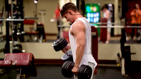 Side-closeup-of-young-bodybuilder-doing-dumbbell-hammer-curls