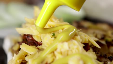 Close-up-of-Mustard-being-topped-onto-Cheese