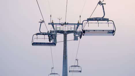 8-person-ski-lift-with-few-to-no-people-during-winter-afternoon-with-a-white-fog-gradient-background-in-Gudauri-Ski-Resort,-Georgia