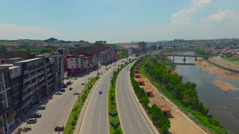 Modellstraße-Und-Stadt-Mit-Gebäuden-Und-Fluss,-Drohnenansicht,-Brücke-Auf-Dem-Fluss,-Autos,-Die-Auf-Der-Straße-Fahren,-Chitwan,-Nepal