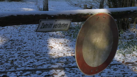 Pan-shot-coming-to-a-stop-on-a-sign-saying-"Zutritt-Verboten"-with-snow-on-the-ground-in-Autumn-in-Germany