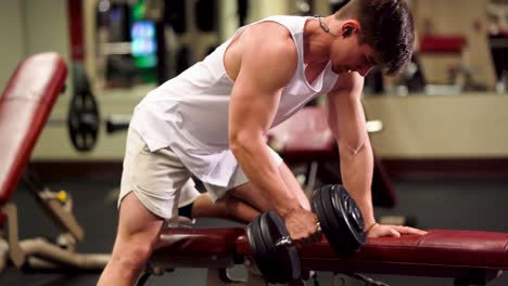 Closeup-side-view-of-young-bodybuilder-doing-one-arm-dumbbell-rows