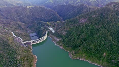Aerial-view-over-Jigüey-dam-near-Nizao-River-surrounded-by-green-mountains-in-Dominican-Republic