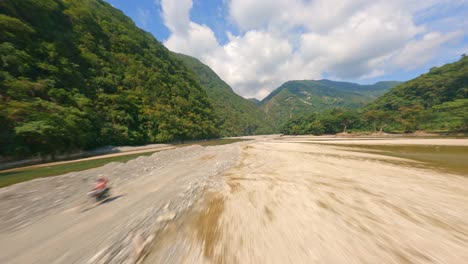 Aerial-flight-over-dried-river-bed-between-green-mountains-in-summer---Muchas-Aguas-in-Dominican-Republic