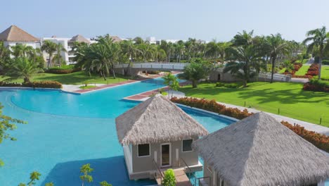 Aerial-flyover-luxury-hotel-resort-with-garden,palm-trees-and-empty-swimming-pool