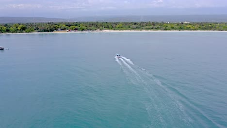 Aerial-View-Of-Boat-Leaving-Wake-On-Calm-Waters-Of-Blue-Sea-Sailing-Towards-Pedernales-Beach-In-Dominican-Republic