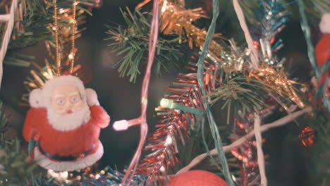 Ornaments-on-a-Christmas-tree-with-Santa-Claus-and-blinking-decorative-light-for-seasonal-new-year-concept