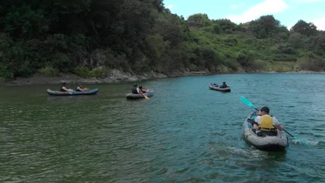 SLOWMO---Young-people-canoeing-on-beautiful-pristine-clear-blue-Pelorus-River,-New-Zealand---Aerial-Drone
