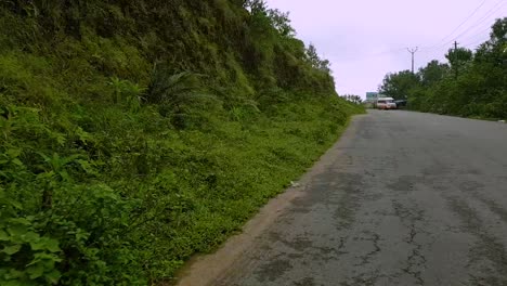 Folgeaufnahme-Eines-Autos,-Das-Um-Die-Haarnadelkurve-In-Den-Bergen-In-Vagamon,-Kerala,-Indien,-Herumfährt