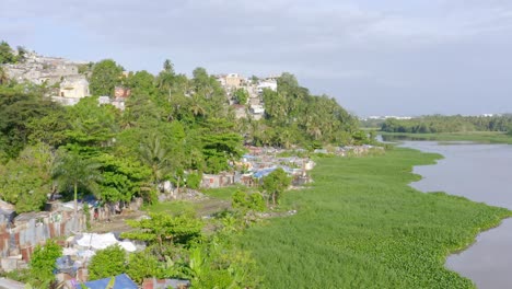 Aerial-forward-over-slum-on-Ozama-river-banks,-Santo-Domingo