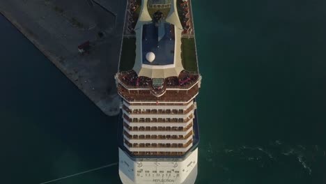 Aerial-topdown-view-of-a-big-cruise-ship-with-people-on-the-upper-deck-while-flying-over-the-cruise-ship-4K