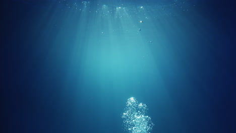 Underwater-sunlight-beams-shining-from-above-coming-through-the-deep-crystal-clear-blue-water-causing-a-beautiful-water-lighting-reflections-curtain-with-air-bubbles-rising-up-to-the-surface