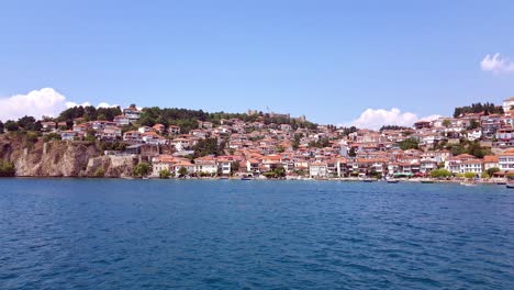 Beautiful-view-of-ancient-Ohrid-City-and-buildings-on-harbor-from-boat-on-water-perspective